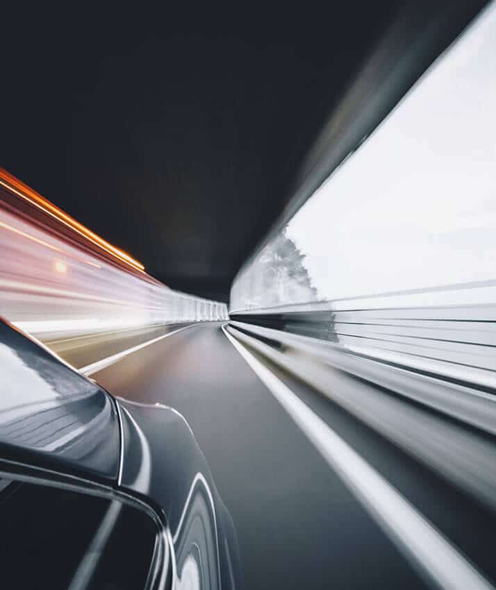 Berline noir de chauffeur taxi vtc sous un pont a tout vitesse